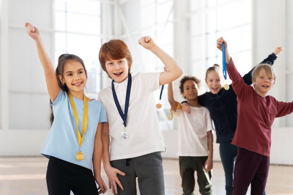 A group of young kids posing with participation medals.